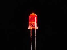 a close up of a red light emitting from a lamp bulb on a black background