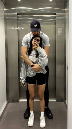 a man and woman taking a selfie in an elevator with their hands on each other's hips