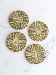 three woven coasters sitting on top of a marble counter