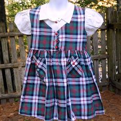 Vintage 50's 60s Girls Macdonald Plaid Cotton School Church Dress Size 5 What A Wonderful Dress! Macdonald Plaid In Red, Green, Ivory & Black Cotton Faux 'Vest' Bodice W/ Decorative Red Buttons On A Arrow Shape Faux White 'Blouse' Under Vest (No Top Button, Doesn't Appear To Have Had One) Short Puff Sleeves 2 Front Pockets W/ Triangle Top & Red Button Belt Loops (No Belt) Full Skirt Unlined No Label Very Good Condition, Appears Unworn Chest: 25" Waist: 25" Hip: Free Length: 21" Shoulder To Shoul Fitted Plaid School Dress, Fitted Plaid Dress For School, Cute Plaid Dresses For School, Plaid Sleeveless School Dress, Sleeveless Plaid School Dress, Plaid Short Sleeve Dress For School, Retro Short Sleeve School Dresses, Retro Fitted School Dress, Retro Fitted Dress For School