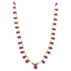 Hand made in the Etruscan style, designed as twenty eight ruby drops of rich deep raspberry colour, with a larger ruby drop in the center, enhanced by high karat gold link beads and tubular links, attached to a high carat gold custom made clasp. 15 ½ in. (39.4 cm.) long. Formal Ruby Gemstone Beads Jewelry, Formal Drop Ruby Necklaces, Formal Ruby Drop Necklace, Big Ruby Necklace, Fine Jewelry Ruby Drop Necklaces, Ruby Teardrop Necklace In Fine Jewelry Style, Luxury Ruby Necklace For Celebration, Pink Ruby Necklace For Celebration, Ruby Gemstone Temple Jewelry Necklace