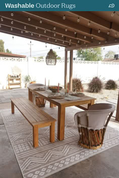 a wooden table sitting on top of a rug under a pergolated patio roof