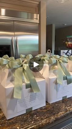 four boxes with green bows on them are sitting on a counter in front of a refrigerator