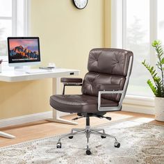 a brown leather office chair sitting in front of a desk with a computer on it