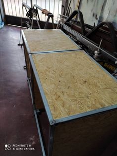 a table that is made out of plywood and some kind of machinery in the background