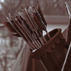 a vase filled with lots of arrows on top of a table