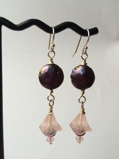 Unique black coin pearls falling from sterling ear hooks hold pretty frosted pink flowers in a long drop earring pair. The flowers are finished off with a purply-gold faceted rondelle and a pink opal Swarovski crystal bicone bead, and have a beautiful, feminine appeal. Elegant Pink Round Bead Flower Earrings, Elegant Pink Round Beaded Flower Earrings, Vintage Nickel-free Drop Flower Earrings, Adjustable Flower-shaped Earrings With Dangling Beads, Elegant Blossom-colored Drop Flower Earrings, Pink Flower-shaped Jewelry With Dangling Beads, Vintage Pink Flower-shaped Earrings, Flower Drop Earrings, Long Drop Earrings