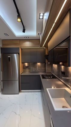 a modern kitchen with stainless steel appliances and marble counter tops, along with white flooring