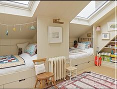 there are two beds in this small room with skylights on the roof and rugs on the floor