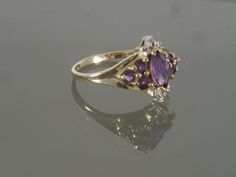 This gorgeous amethyst ring is sure to please! It is crafted of 18k yellow gold and features a stunning colored natural amethyst. This ring also features tiny round brilliant cut diamond accents on the top and bottom of the face. This would make a great Valentines Day, February Birthstone, or Anniversary gift. This ring will be shipped in a brand new gift box. RING SIZE: 7.25 (Sizable by your local jeweler) Metal: 18k Yellow Gold (Verified by acid test) Gemstone: 1 Marquise Natural Amethyst (app Gig Harbor Wa, Gig Harbor, Diamond Accent Ring, Box Ring, Amethyst Gem, Wedding Ring Box, Natural High, Purple Band, February Birthstone