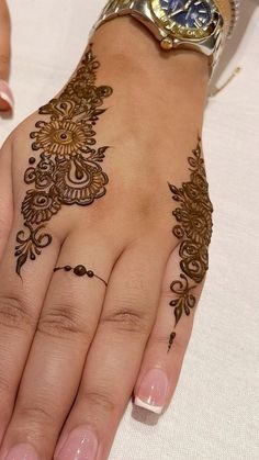 a woman's hand with henna tattoos on it