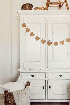 a white cabinet with hearts hanging from it