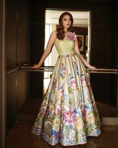 a woman in a long dress standing on a railing