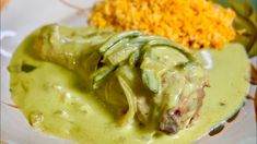 a white plate topped with food covered in green sauce