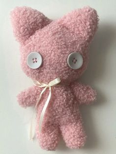 a pink teddy bear with buttons on it's eyes