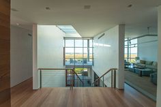 an open living room with wood floors and large windows on the side of the wall