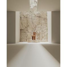 an empty room with a chair in the center and light coming through it to reveal a stone wall