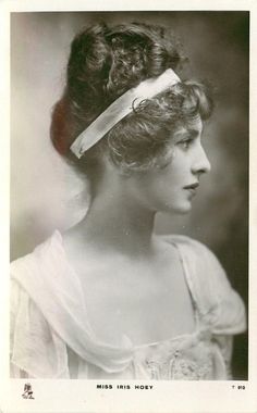 an old black and white photo of a woman with a headband on her hair