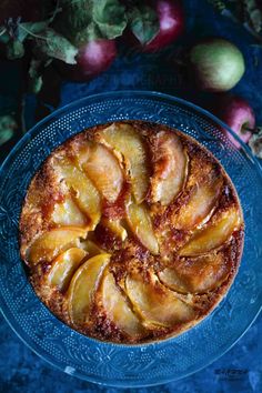 a blue plate topped with a pie covered in apples