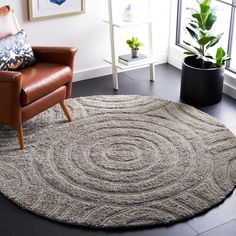 a living room area with a chair, rug and potted plant in the corner