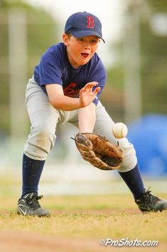 a young boy catching a baseball with his glove