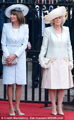 two women standing next to each other on a red carpet