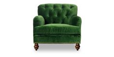 a green velvet chair with gold trimmings on the legs and back, sitting in front of a white background