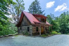 an old log cabin sits in the middle of a wooded area, surrounded by trees