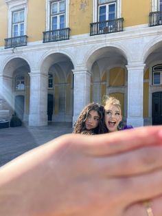 two women taking a selfie in front of a building