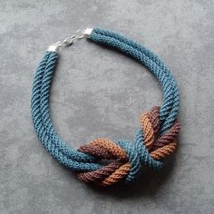 a multicolored rope necklace on a gray surface