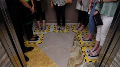 several people standing in an elevator with their feet on the ground and one person wearing flip flops