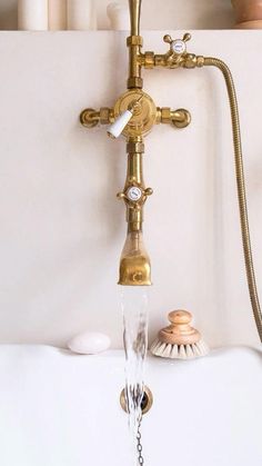 a faucet with water running from it and seashells in the background