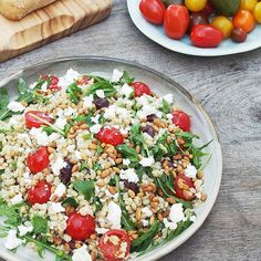 a salad with tomatoes, lettuce and feta cheese is on a plate