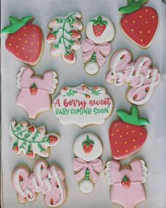 a box filled with lots of decorated baby shower cookies on top of a white table