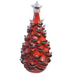 a red glass christmas tree ornament sitting on top of a table