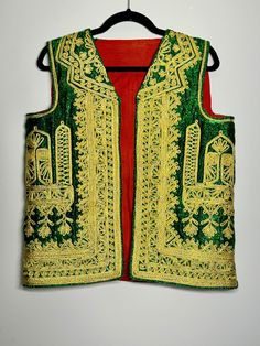 Made in Afghanistan, this a rare find vintage sleeveless waistcoat. Hand embroidery on velvet. A very antique piece in mint condition.  Measurements in inches (flat):  Shoulder: 15 Bust: 20 Length: 24 Note: Worn and minor signs of wear. Festive Vest With Intricate Embroidery, Festive Sleeveless Vest With Intricate Embroidery, Sleeveless Embroidered Vest For Festive Occasions, Festive Embroidered Sleeveless Vest, Festive Sleeveless Embroidered Vest, Traditional Festive Vest With Intricate Embroidery, Festival Vest With Intricate Embroidery, Vintage Embroidered Vest For Festivals, Festive Bohemian Vest With Intricate Embroidery