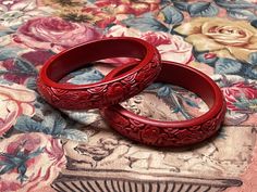 Item Details. Dating from the early 20th century a pair of beautifully carved cinnabar bracelets.  Made in China with the painstaking and time consuming craft where layers and layers of lacquer are built up, dried, and then intricately carved with symbolic motifs including clouds, with dragons chasing pearls. As with many hand crafted items, these have a wonderful tactile quality and are wonderful to wear. Era and Usage. From the 1920s and in wonderful, ready to wear condition. Measurements. 3 1/4 inches across  (8.5 cm) Condition. In wonderful, ready to wear condition with no damage that we can find. Further Notes. We have lots more original and quality vintage items and textiles in our shop, https://www.etsy.com/uk/shop/TheTextileTreasury Where possible, we use recycled packaging when sh Vintage Carved Bracelets For Ceremonial Occasions, Vintage Handmade Red Bangle, Carved Red Vintage Jewelry, Red Carved Vintage Jewelry, Vintage Red Bracelet For Wedding, Vintage Red Bracelets For Wedding, Red Vintage Bangle For Wedding, Vintage Red Wedding Bracelet, Red Bracelets