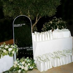 an outdoor wedding setup with white flowers and greenery