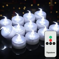 many white candles are lit up with remote controls