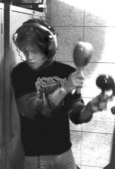 a young man is holding two hair dryers in his hands