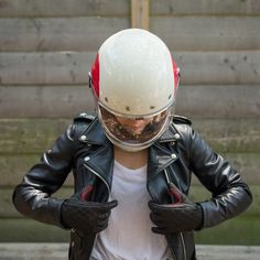 a man wearing a motorcycle helmet and leather gloves