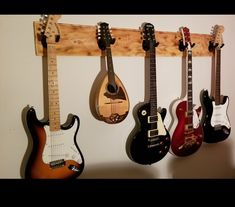 four guitars are hanging on the wall