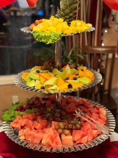 three tiered trays filled with different types of fruits and vegetables on top of each other