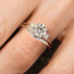 a woman's hand with a diamond ring on her left and an engagement ring on her right