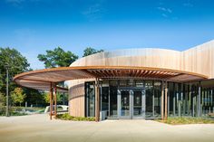 a large circular building with glass doors and wooden roof