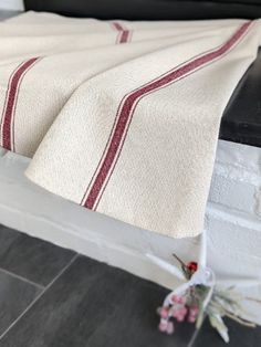 a white and red blanket sitting on top of a bed