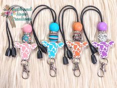 four different colored giraffe key chains on a white furnishing with the words happy new year written across them