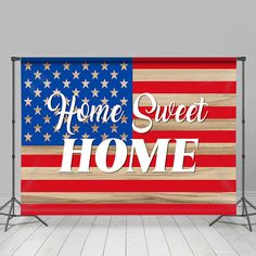 an american flag with the words home sweet home written on it in front of a backdrop