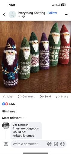 several knitted santas lined up in rows on top of a wooden table next to each other