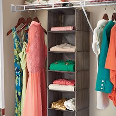 an organized closet with clothes, shoes and other items hanging on the rack in front of it